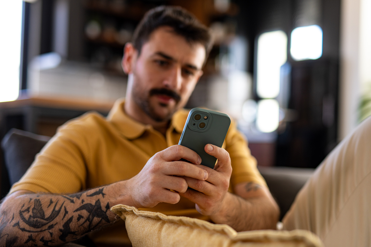 Man on couch using app