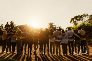 Group standing with arms around each other’s shoulders