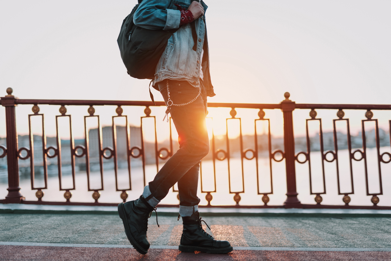Man in leather boots walking at sunset