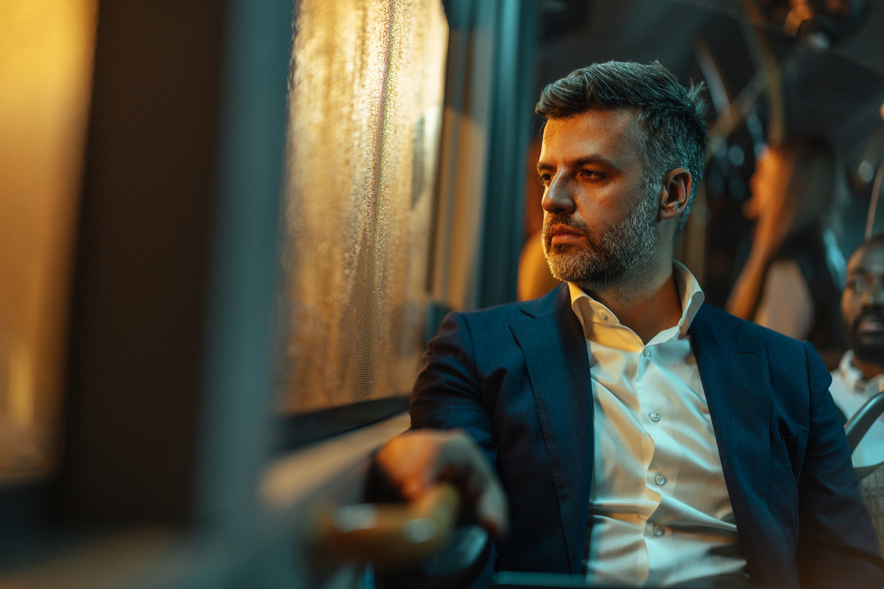 Business man reflecting out the train window on a nightly commute