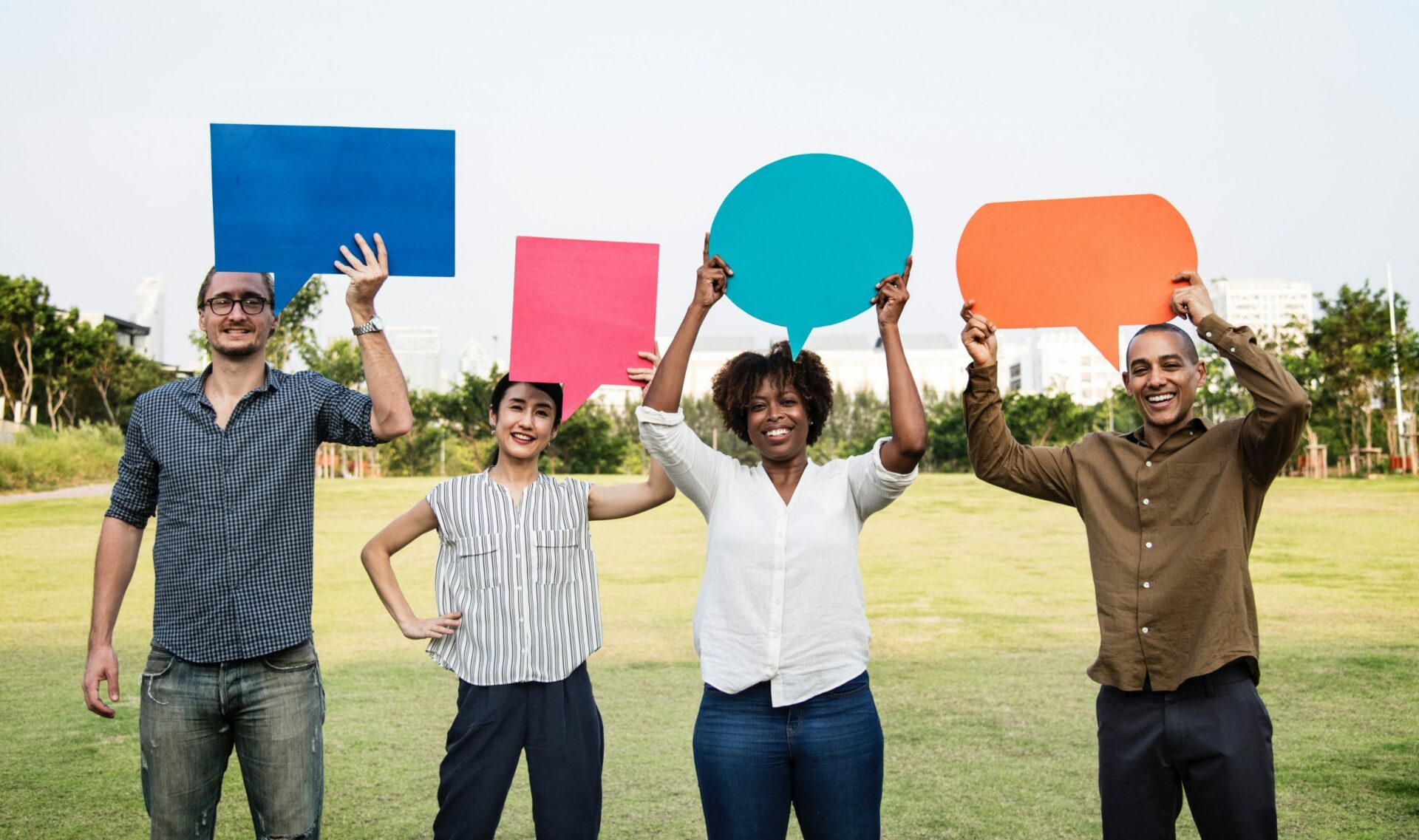 group of people holding up chat bubble shapes